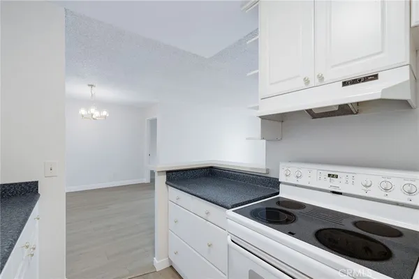 a kitchen with white cabinets and white stove