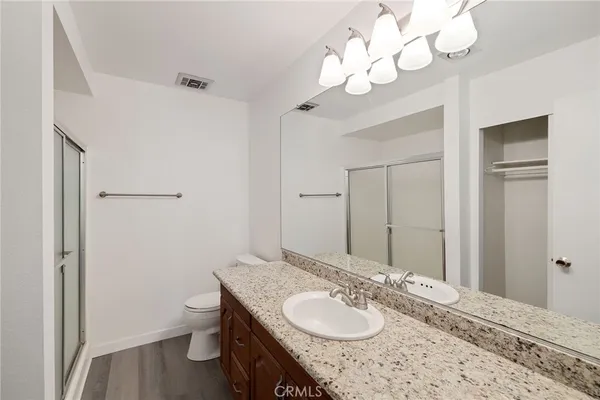a bathroom with a granite countertop sink a toilet and a mirror