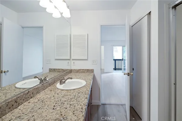 a bathroom with a granite countertop sink and mirror