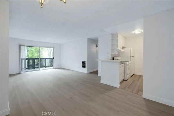 a view of a kitchen with furniture and wooden floor