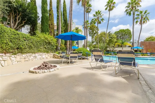 a view of a patio with a table and chairs under an umbrella