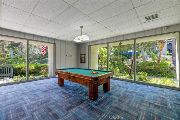 a room with pool table and windows