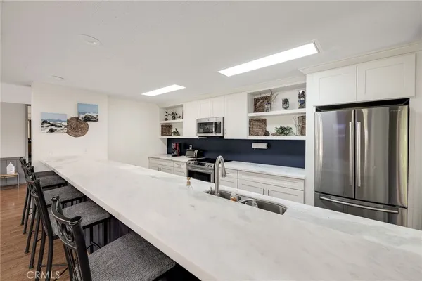 a living room with furniture and a refrigerator