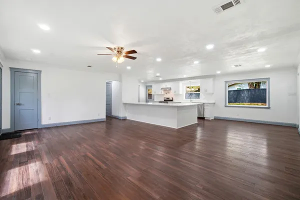 a view of a kitchen with wooden floor and a ceiling fan