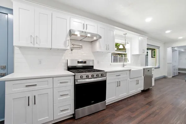 a kitchen with cabinets a sink and appliances