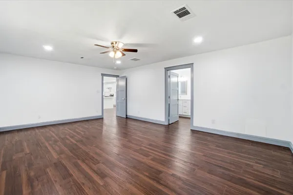 a view of an empty room with window and wooden floor