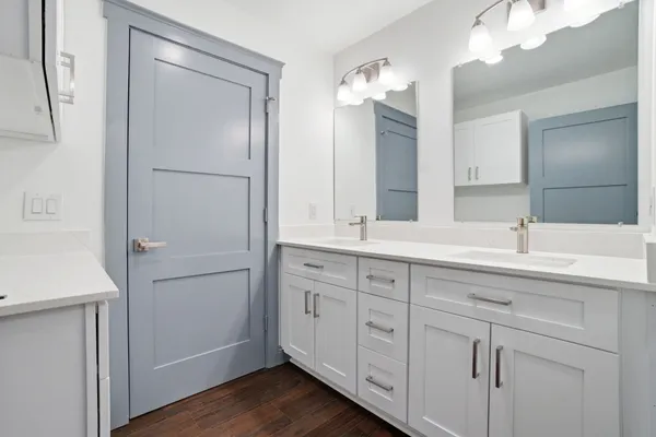 a bathroom with a double vanity sink mirror and cabinets