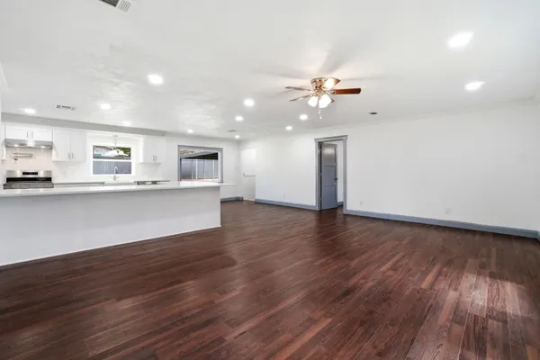 a view of a kitchen with a sink a ceiling fan and wooden floor