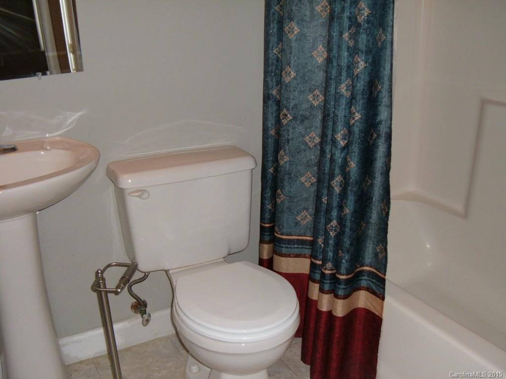 3527 East North Corner Road Lancaster, SC 29720 - Photo 12 of 23 a white toilet sitting next to a bathroom sink and tub
