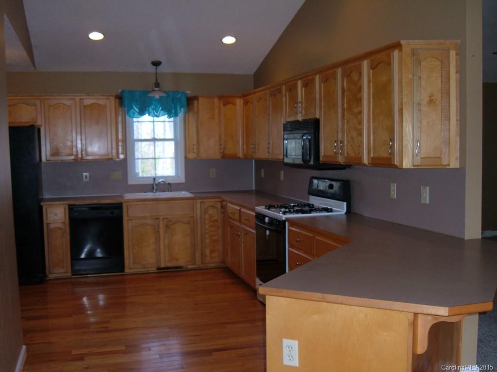 3527 East North Corner Road Lancaster, SC 29720 - Photo 5 of 23 a kitchen with kitchen island granite countertop wooden cabinets a stove and a sink