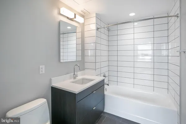 a bathroom with a sink toilet vanity and bathtub
