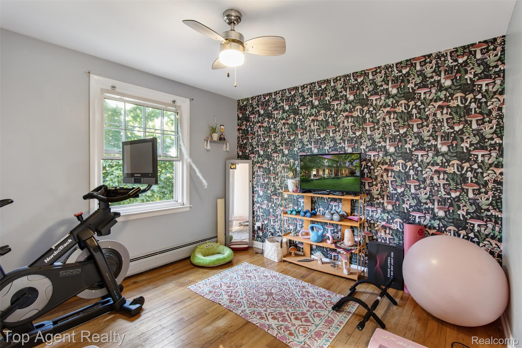 32341 Woody Road Fraser, MI 48026 - Photo 27 of 47 Room featuring a decorative accent wall, wood-finish flooring, a ceiling fan, and a window with white trim