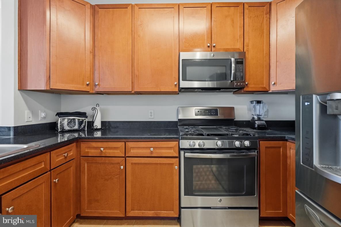 8045 Newell Street, Unit 423 Silver Spring, MD 20910 - Photo 16 of 26 a kitchen with stainless steel appliances granite countertop a stove a sink and a microwave