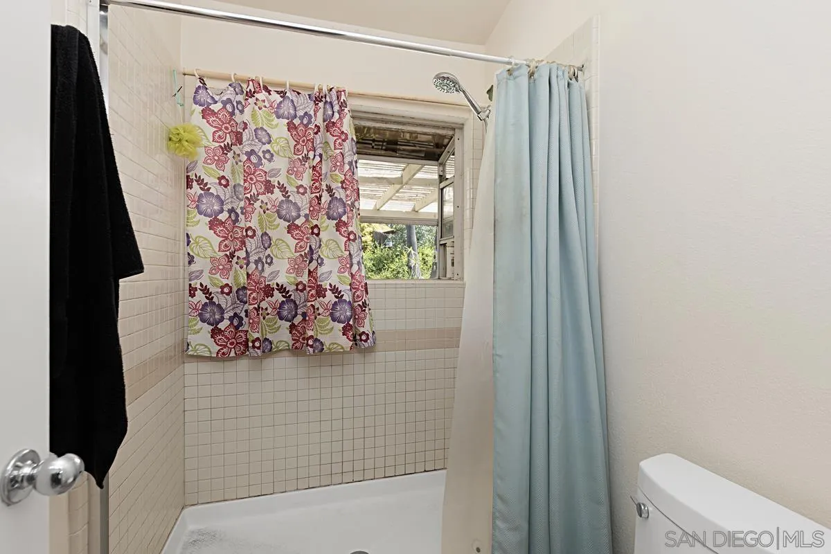 1505 Avenida Oceano Oceanside, CA 92056 - Photo 18 of 26 a bathroom with a toilet and a shower curtain