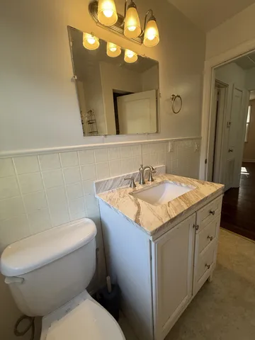a bathroom with a granite countertop toilet sink and mirror