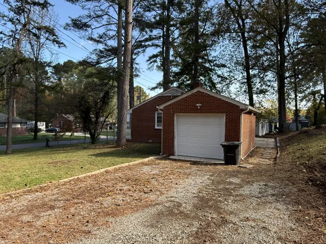 a view of a house with a yard and large tree