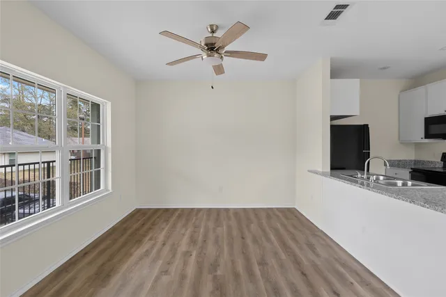 a view of a livingroom with a hardwood floor and a ceiling fan