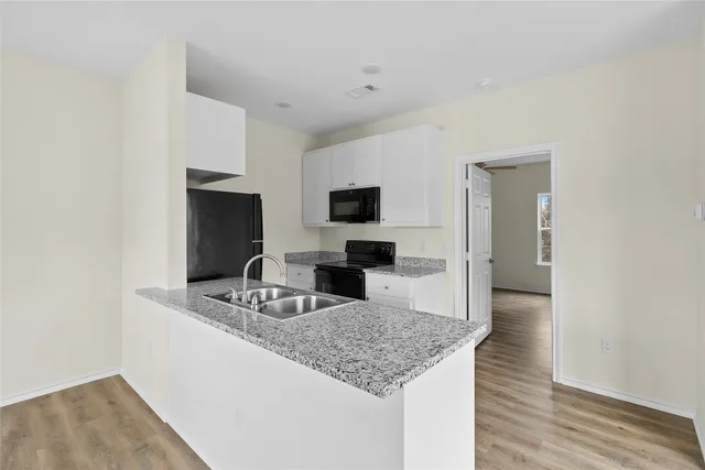 a kitchen with granite countertop a sink and a stove top oven