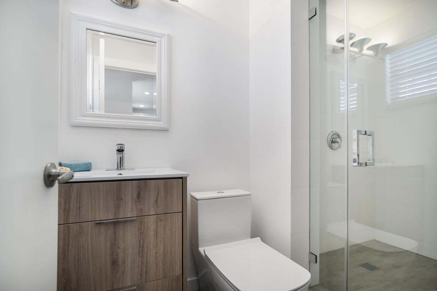 1605 Pennsylvania Avenue, Unit 502 Miami Beach, FL 33139 - Photo 11 of 21 a bathroom with a toilet a sink and mirror