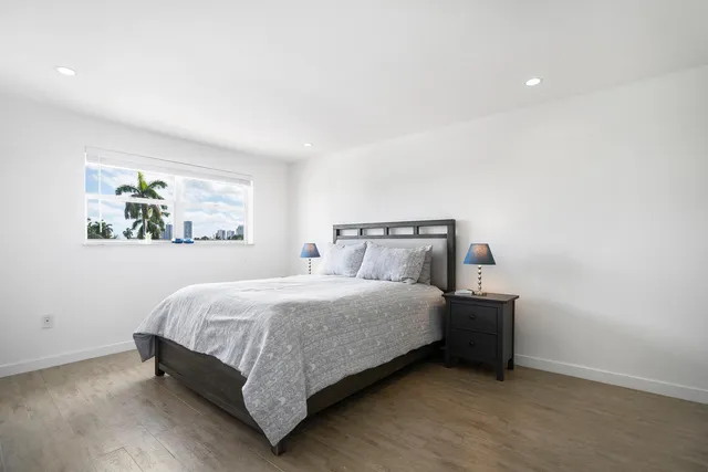 a bedroom with a bed and painting on the wall