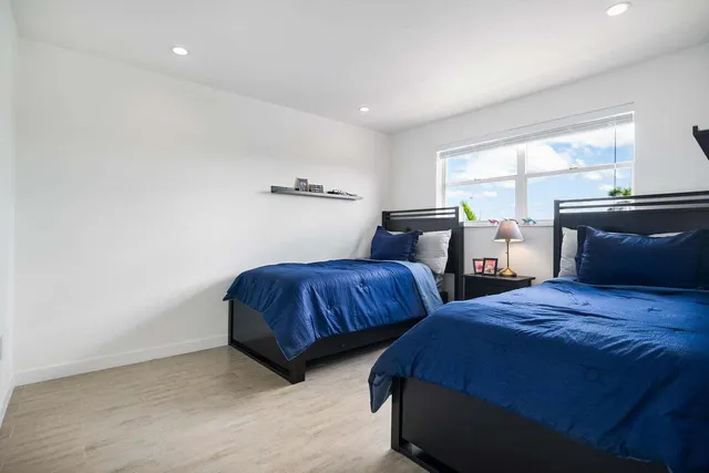 a bedroom with two beds and painting on the wall