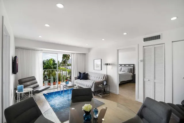 a living room with furniture floor to ceiling window and a table