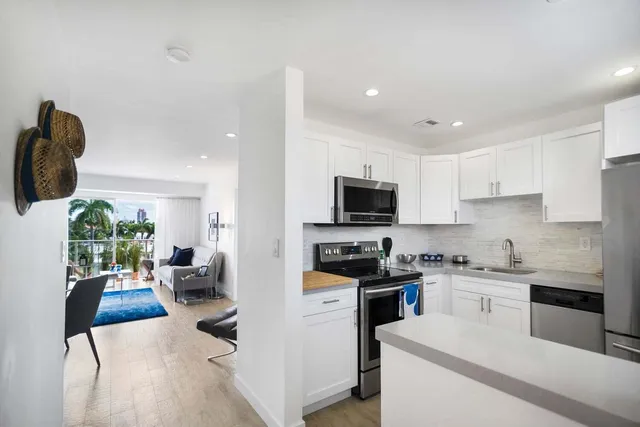 a kitchen with white cabinets and appliances