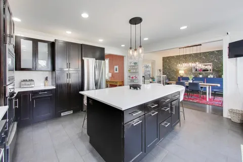 a kitchen with stainless steel appliances granite countertop a sink a stove and a refrigerator