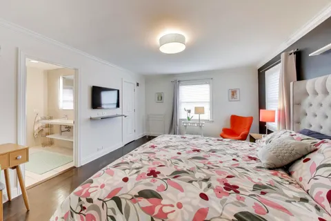 a bedroom with a bed and wooden floor