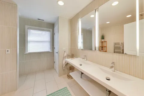 a bathroom with a tub a sink and a large mirror