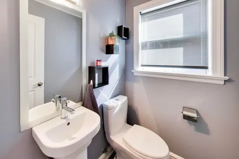 a bathroom with a toilet sink and mirror