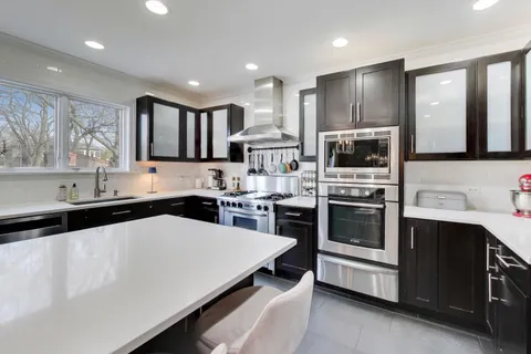 a kitchen with kitchen island granite countertop a sink stainless steel appliances and cabinets