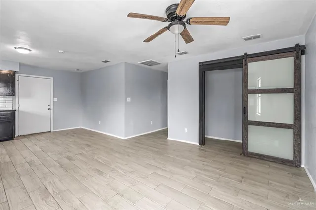 an empty room with closet and a ceiling fan