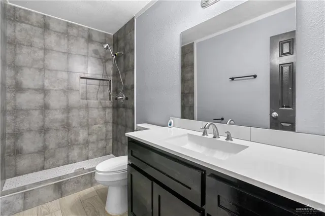 a bathroom with a sink a toilet and shower