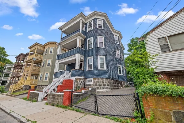 a front view of a residential apartment building with a yard