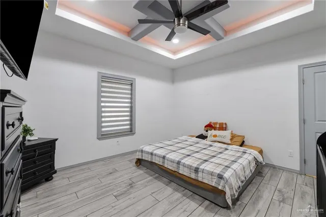 a bedroom with a bed a flat screen tv and dresser