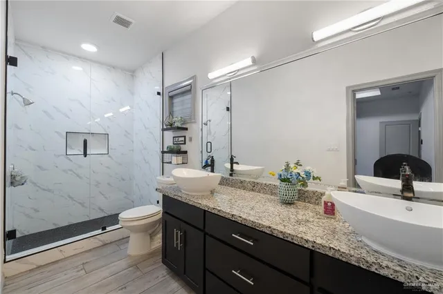 a bathroom with a granite countertop sink a toilet and a bathtub