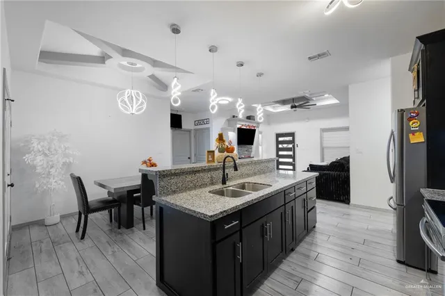 a kitchen with stainless steel appliances granite countertop a sink and a refrigerator