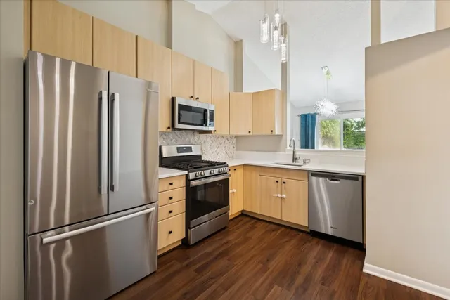 a kitchen with stainless steel appliances a refrigerator sink and microwave
