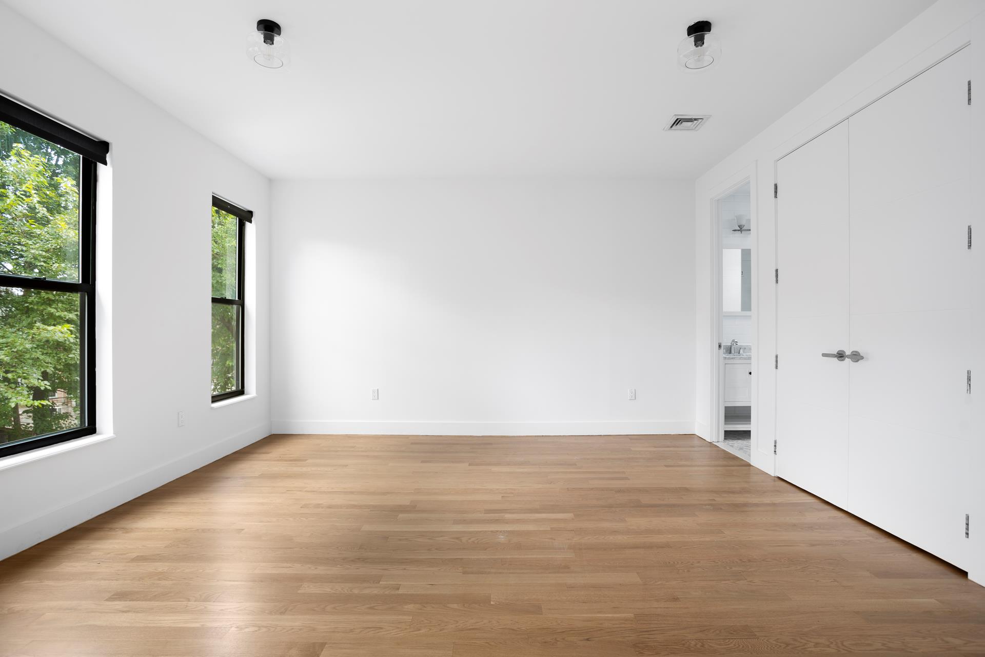274 Eldert Street Brooklyn, NY 11207 - Photo 10 of 18 a view of an empty room with wooden floor and a window