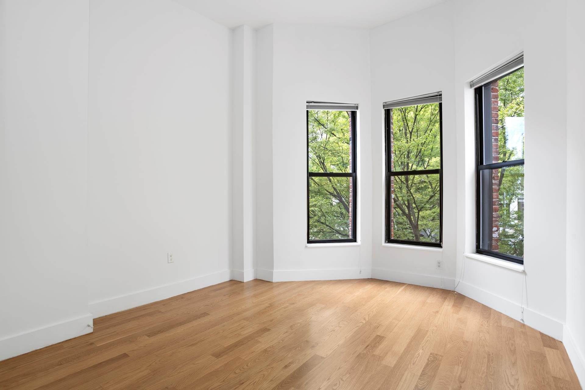 274 Eldert Street Brooklyn, NY 11207 - Photo 13 of 18 an empty room with wooden floor and windows