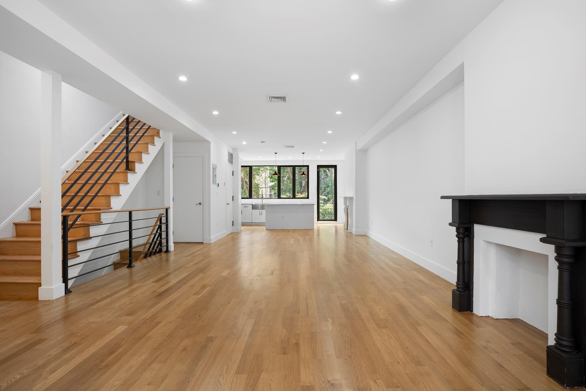 274 Eldert Street Brooklyn, NY 11207 - Photo 8 of 18 a view of an empty room with wooden floor and a kitchen