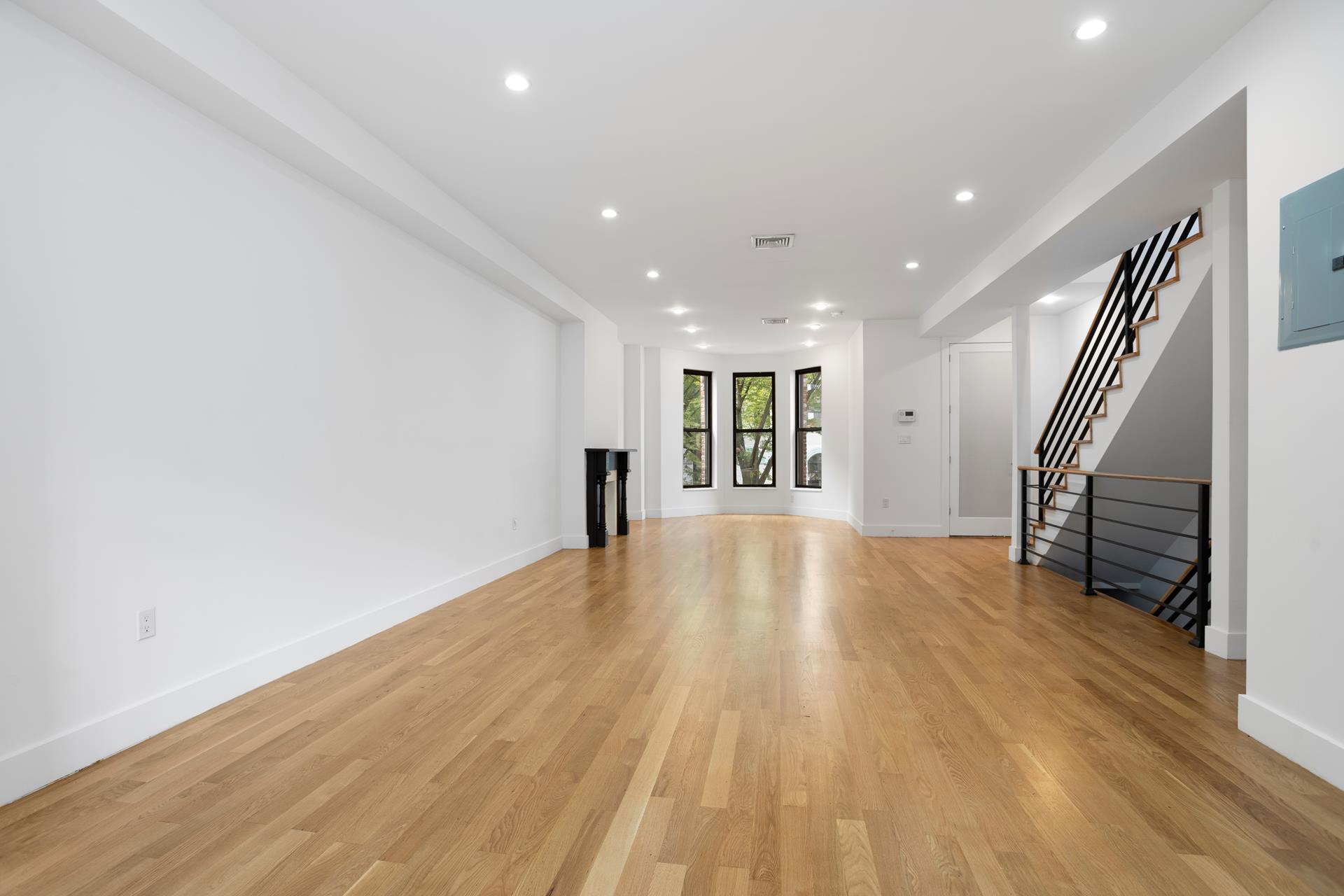 274 Eldert Street Brooklyn, NY 11207 - Photo 9 of 18 a view of empty room with wooden floor and stairs