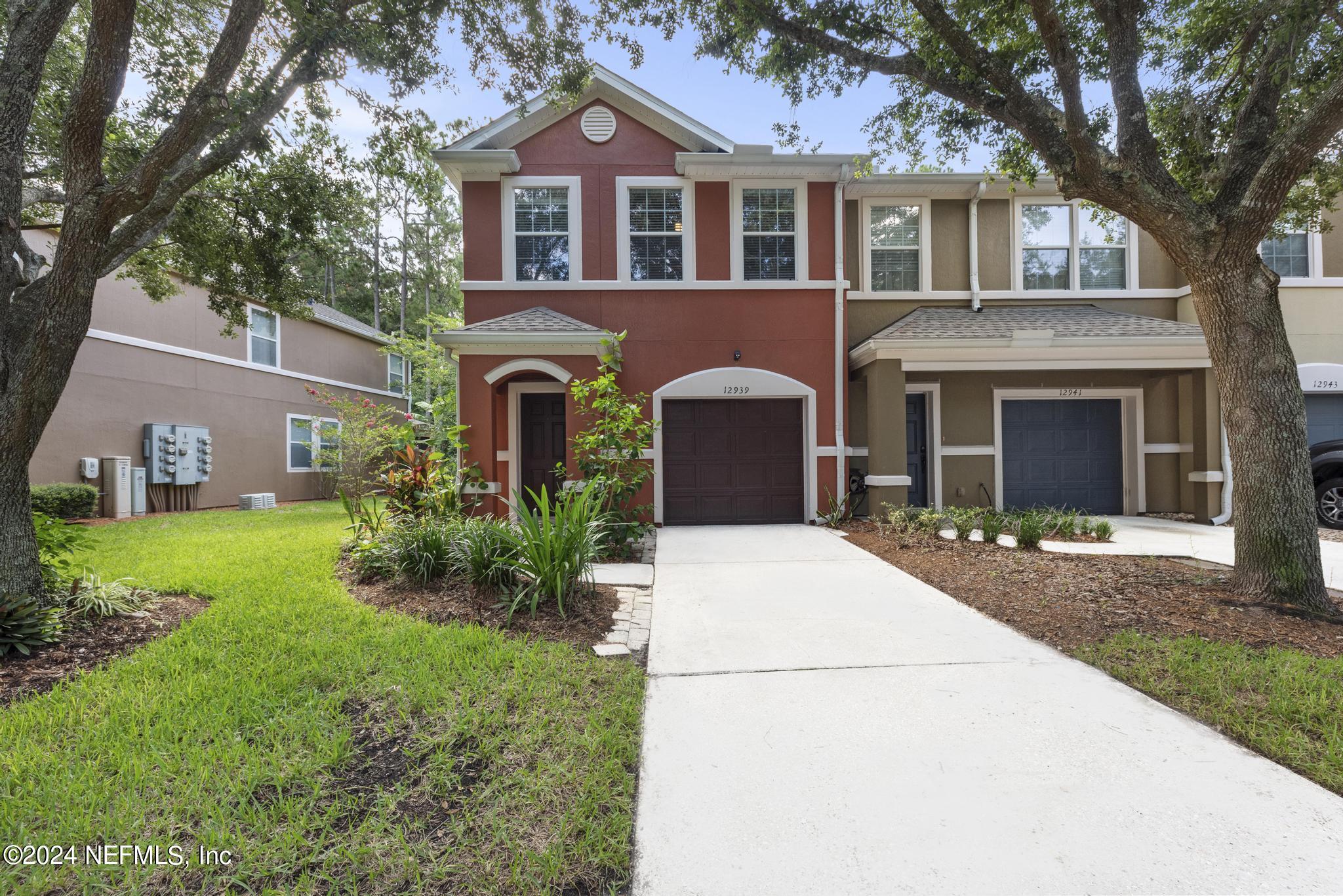 12939 Spring Rain Road Jacksonville, FL 32258 - Photo 1 of 30 a front view of a house with a garden and yard