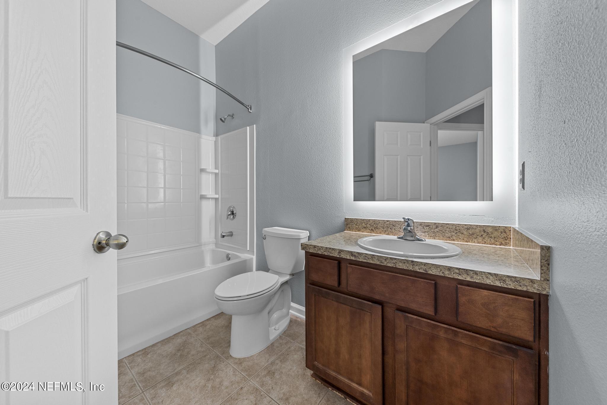 12939 Spring Rain Road Jacksonville, FL 32258 - Photo 18 of 30 a bathroom with a granite countertop sink a toilet and a mirror