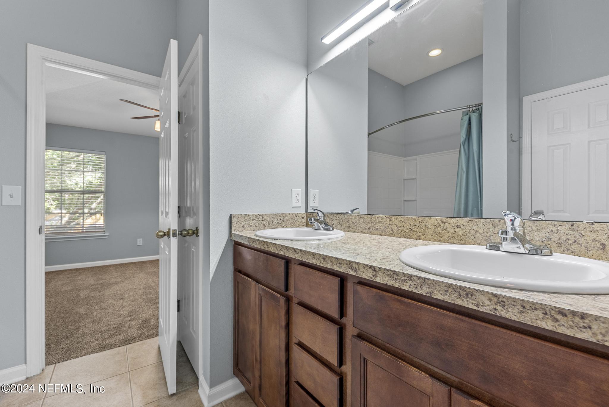 12939 Spring Rain Road Jacksonville, FL 32258 - Photo 23 of 30 a bathroom with a granite countertop sink and a mirror