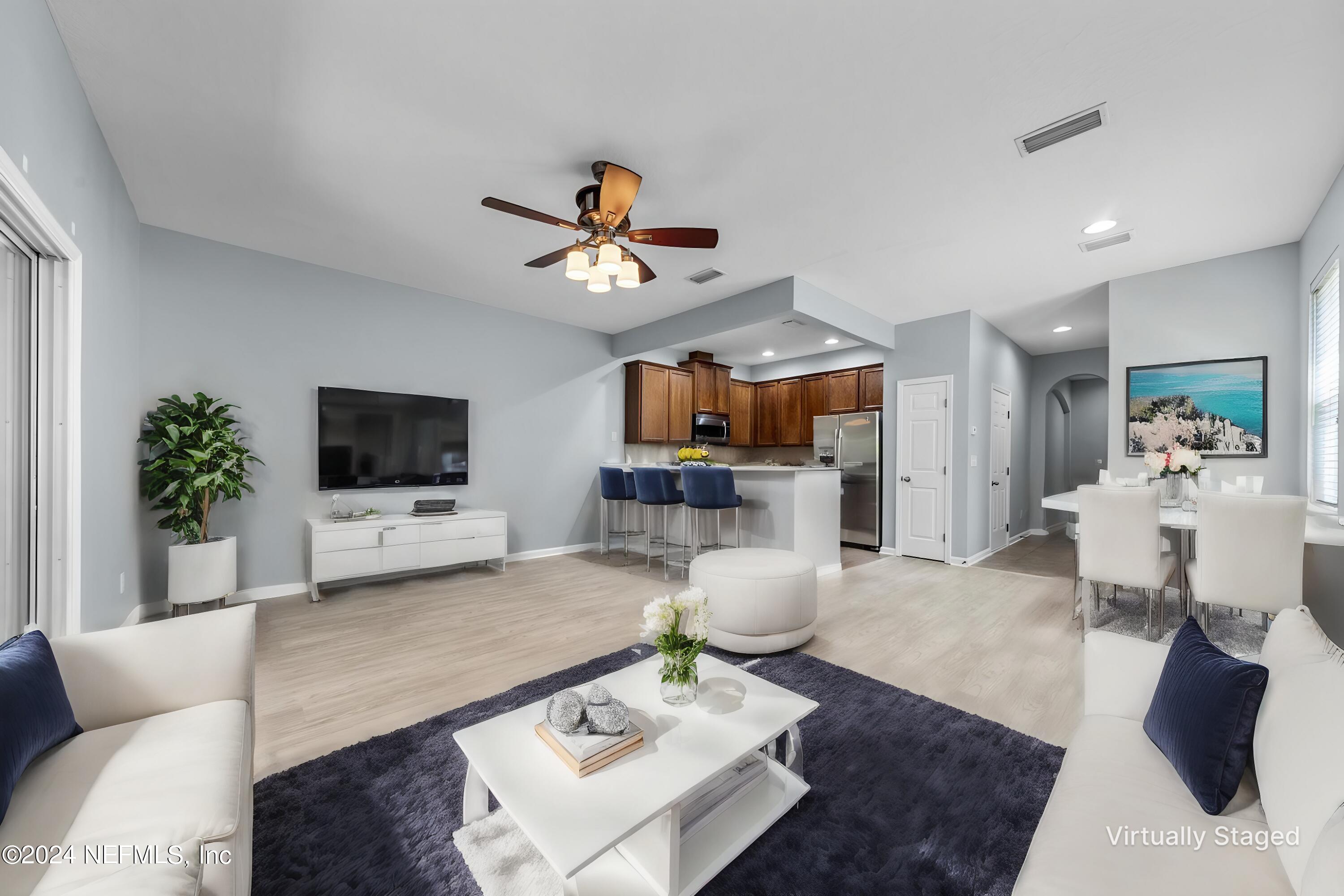 12939 Spring Rain Road Jacksonville, FL 32258 - Photo 5 of 30 a living room with furniture a flat screen tv and a table