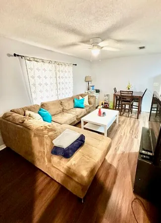 a living room with dining room and wooden floor
