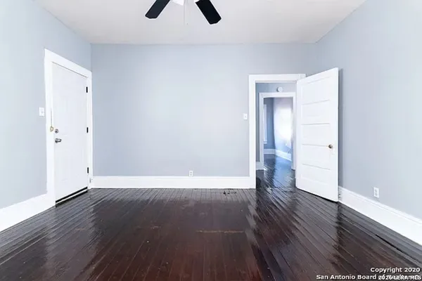 a view of an empty room with wooden floor