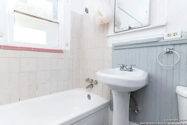 a bathroom with a sink a toilet and a mirror